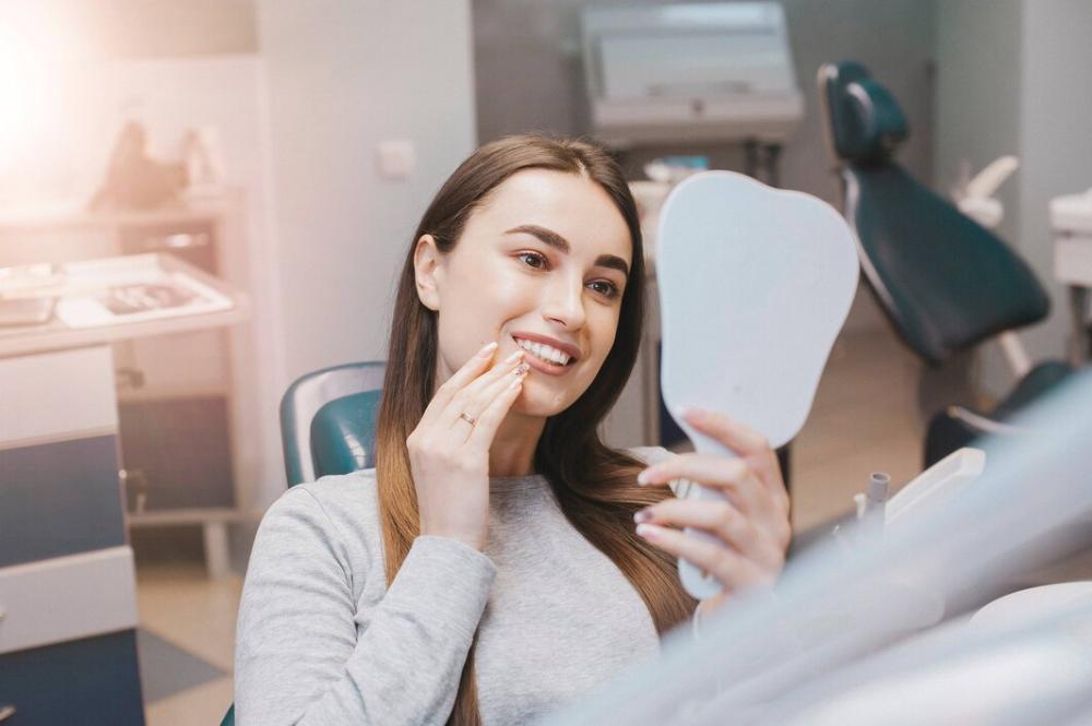 woman checking her tooth crown chesterfield mo