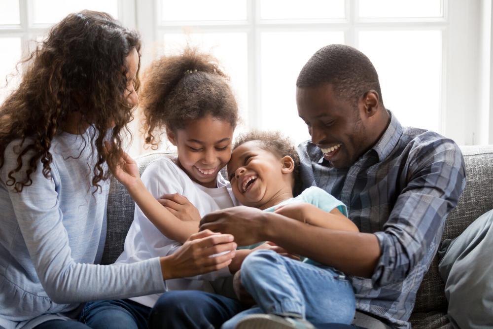 Father, daughter, and two young children smiling