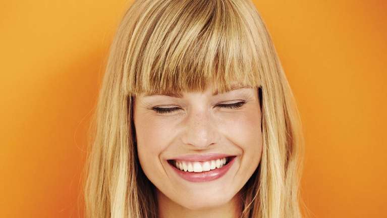 woman smiling in orange background