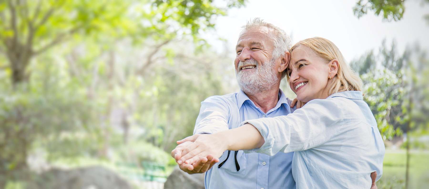 Two people happily dancing outdoors with their dental implant in Chesterfield MO